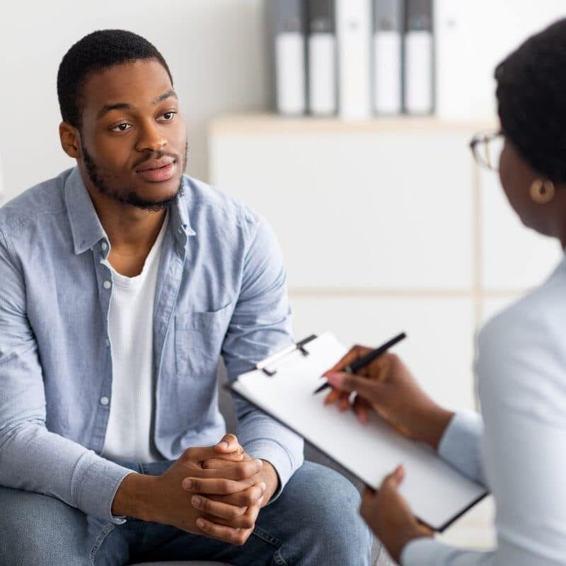 Homem negro conversando com um conselheiro de saúde mental