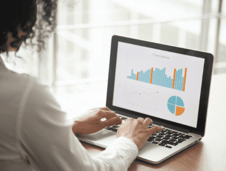 Mulher trabalhando em seu computador olhando gráficos