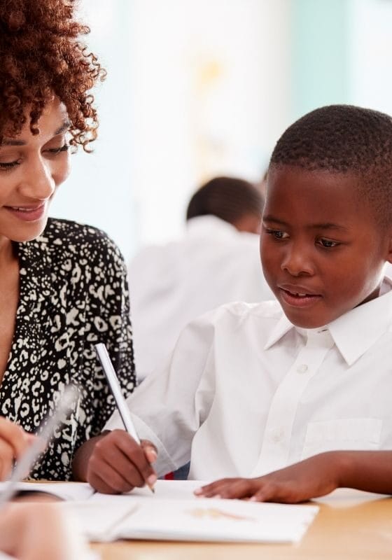 Aluno do ensino fundamental recebendo ajuda do professor