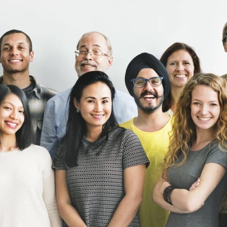 Um grupo diversificado de pessoas sorrindo para a câmera