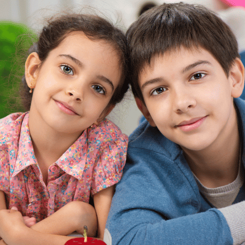 Um menino e uma menina sorrindo e olhando para a câmera
