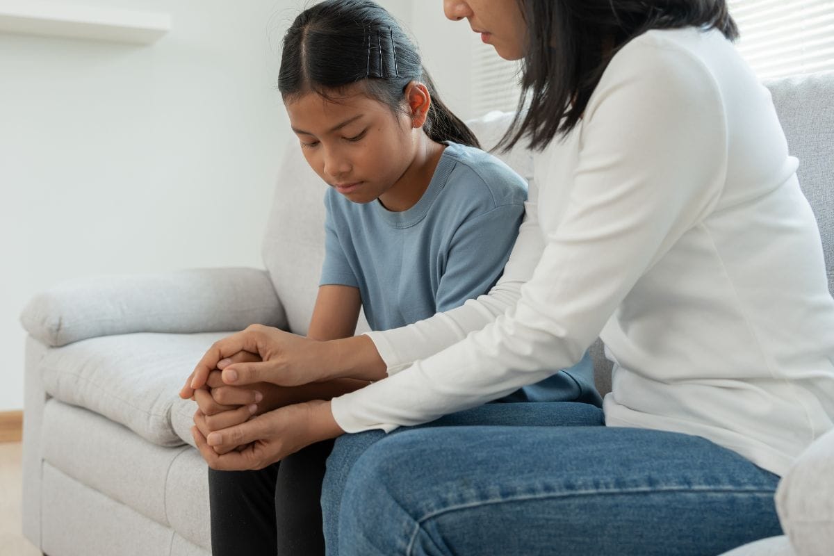 Mãe confortando filha lutando com saúde mental