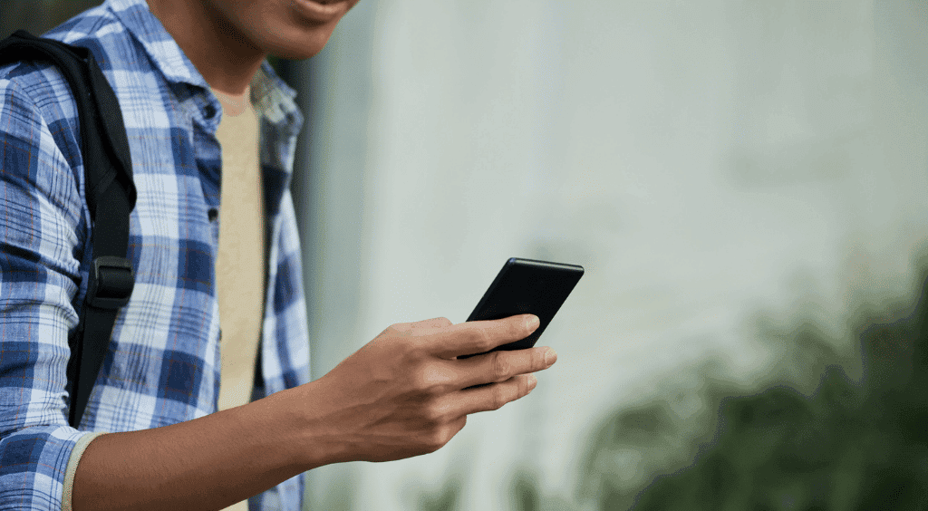 Adolescente andando e olhando para o telefone
